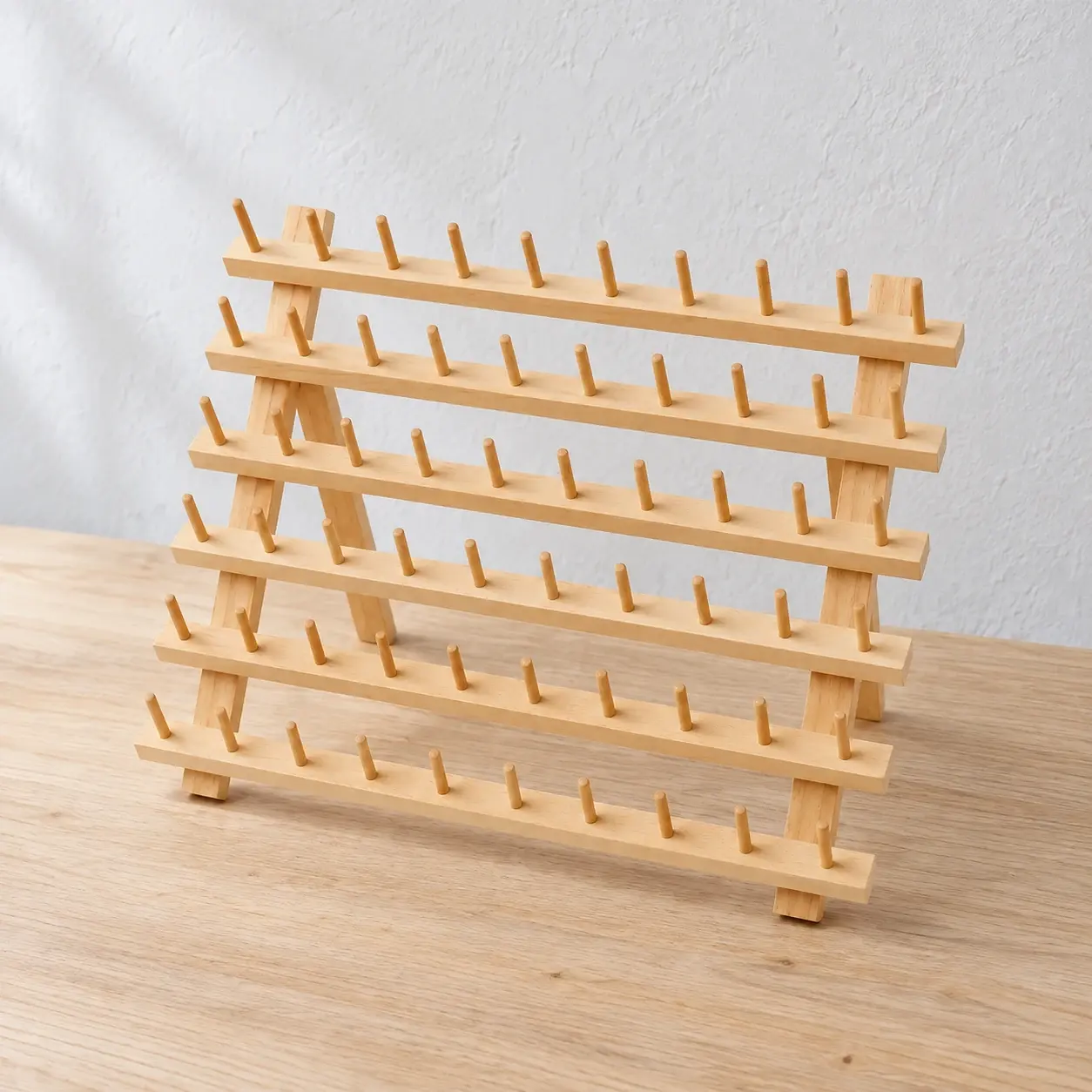 Natural wooden spool rack with six rows of ten pegs