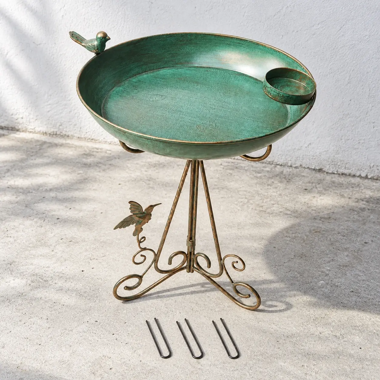 Green-bronze bird bath and three loose ground pins