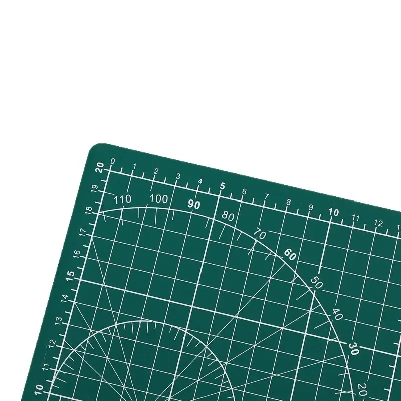 Close view of the green cutting mat’s printed grid and angle guides